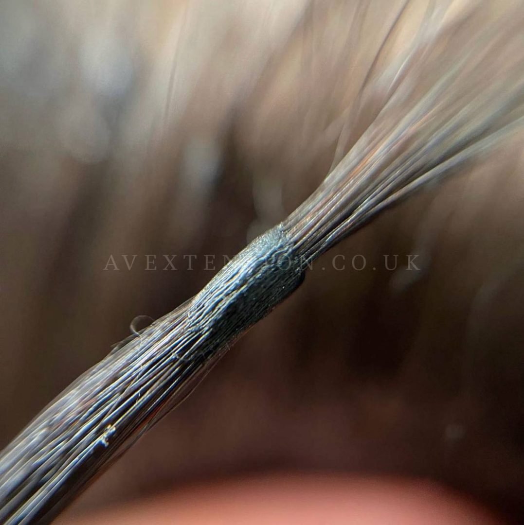 Close-up of an invisible flat micro bond keratin capsule on fine hair, AV Extension London
